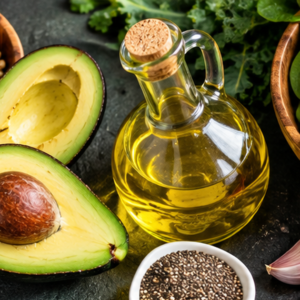 A fresh Mediterranean diet spread featuring olive oil, wild berries, walnuts, avocados, and colorful leafy vegetables.